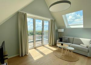 a living room with a couch and a large window at Westeroog in Wangerooge