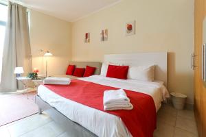 a bedroom with a large bed with red pillows at RH - Beautiful canal view, Sleek & spacious Studio, central location in Dubai