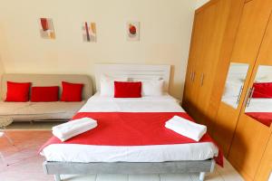 a bedroom with a large bed with red pillows at RH - Beautiful canal view, Sleek & spacious Studio, central location in Dubai