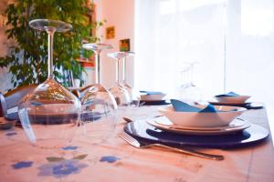 una mesa con copas de vino y platos en ella en ROERooms, en Vezza d'Alba