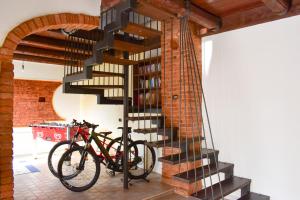 dos bicicletas estacionadas junto a una escalera de caracol en ROERooms, en Vezza d'Alba