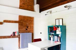 Habitación con escritorio blanco y estante de libros azul. en ROERooms, en Vezza d'Alba