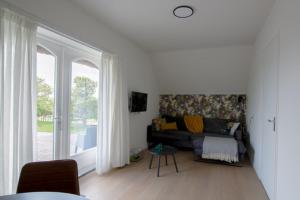 ein Wohnzimmer mit einem Sofa und einem großen Fenster in der Unterkunft Oppe Klincke in Franeker