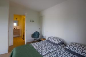 ein Schlafzimmer mit einem Bett und einem blauen Stuhl in der Unterkunft Oppe Klincke in Franeker