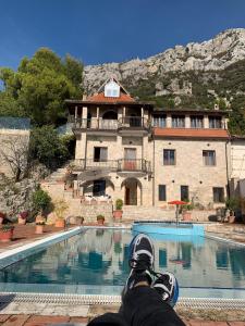 une personne assise devant une maison avec piscine dans l'établissement Villa Celaj “The Castle”, à Krujë