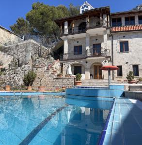 a house with a swimming pool in front of a building at Villa Celaj “The Castle” in Krujë