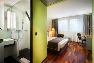 a hotel room with a bed and a shower at Holiday Inn Zürich Messe, an IHG Hotel in Zürich