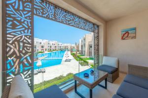 uma sala de estar com vista para a piscina em High Standard 2-Bedroom in Mangroovy Residence, Pool View & Beach em Hurghada