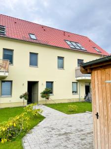 een huis met een rood dak en een oprit bij Ferienwohnung Kamrath mit wunderschönem Ausblick in Neuruppin