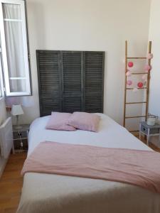勒克魯西克的住宿－Maison au calme, proche centre et mer, jardin clos，卧室配有一张大床和两个粉红色枕头