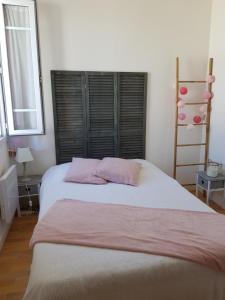 a bedroom with a large bed with two pink pillows at Maison au calme, proche centre et mer, jardin clos in Le Croisic