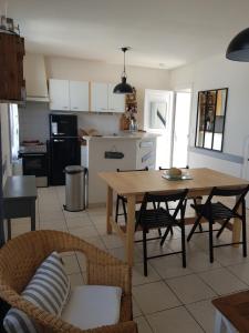 a kitchen with a wooden table and chairs and a table and a table at Maison au calme, proche centre et mer, jardin clos in Le Croisic +4 photos