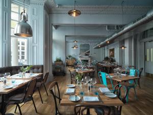 ロンドンにあるRadisson Blu Hotel, London South Kensingtonの木製のテーブルと椅子のあるダイニングルーム