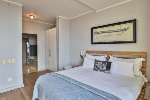 a bedroom with a bed with a picture on the wall at Harbour Bridge 417 by CTHA in Cape Town