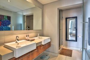 a bathroom with two sinks and a mirror at Harbour Bridge 417 by CTHA in Cape Town
