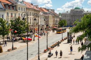 ワルシャワにあるDwupokojowe mieszkanie w Centrumの歩行者とバスが並ぶ街道