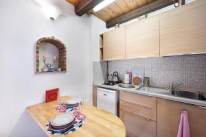 a kitchen with a wooden table and a sink at Ca' Kira in Molini di Triora