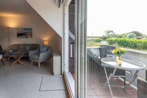 Zimmer mit einem Balkon mit Tisch und Stühlen in der Unterkunft Jutta, App 6 in Wenningstedt-Braderup