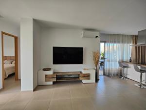 a living room with a flat screen tv on a wall at Garden Suites luxury apartment in Palm-mar