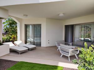 a patio with white furniture and windows at Garden Suites luxury apartment in Palm-mar