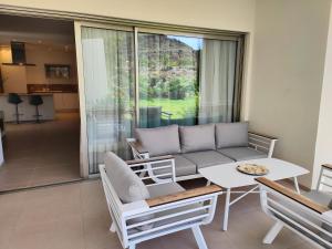 Garden Suites luxury apartment في بالم مار: غرفة معيشة مع أريكة وطاولة