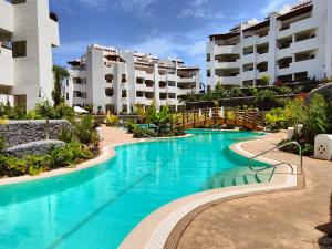 a swimming pool in front of some apartment buildings at Garden Suites luxury apartment in Palm-mar