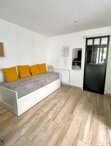 a bedroom with a bed with yellow pillows on it at Charmant studio au coeur du centre ville in Chagny