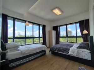 a bedroom with two beds and large windows at ONE Homestay B 6Pax 2Rooms in Sibu