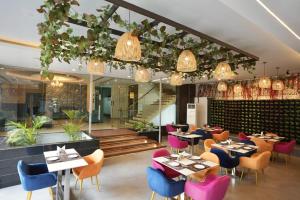 un restaurante con mesas, sillas y luces en Hotel Windsor Heights, en Gurgaon