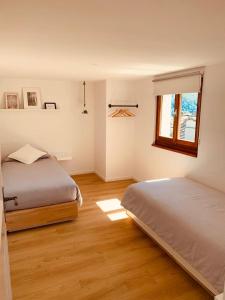 1 dormitorio con 2 camas y ventana en Casa Mille Sassi, en Lionza