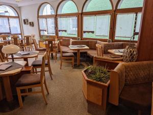 un restaurante con mesas, sillas y ventanas en Cafe-Bäckerei-Pension Weigl, en Oberviechtach
