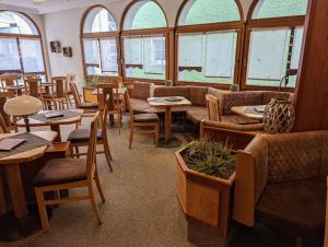 a restaurant with tables and chairs and windows at Cafe-Bäckerei-Pension Weigl in Oberviechtach