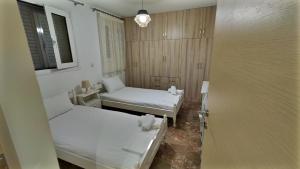 a small room with two beds and a window at kostas apartment in Vlikhón