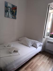 1 cama blanca con 2 almohadas en una habitación en Guesthouse BiT Accommodation en Kotor