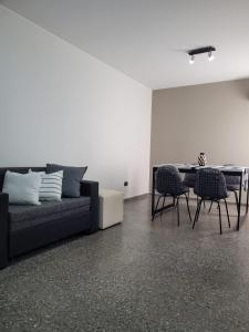 BE Apartments Vicente في ميندوزا: غرفة معيشة مع أريكة وطاولة وكراسي