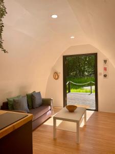 a living room with a couch and a table at Nightjar Cabin at Cloudshill Glade in Wareham