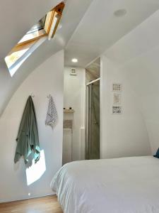 a bedroom with a white bed and a window at Nightjar Cabin at Cloudshill Glade in Wareham