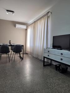 sala de estar con TV, mesa y sillas en BE Apartments Vicente en Mendoza