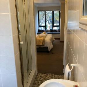 un bagno con lavandino e un letto in una camera di Pelican Lodge Guesthouse a Sedgefield