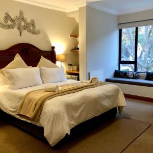 Un dormitorio con una cama grande y una ventana en Pelican Lodge Guesthouse, en Sedgefield