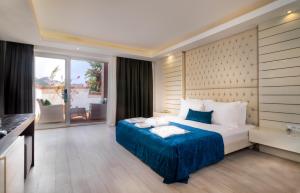 a bedroom with a large bed and a large window at Highlight Hotel in Yalıkavak