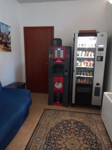 a refrigerator and a drink cooler next to a door at Gardafarm agriturismo in Verona