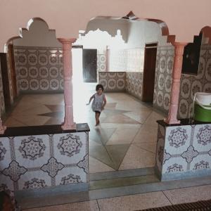 a little girl walking in a room with tiles at Dar Brahim Resto Beds in Ouarzazate