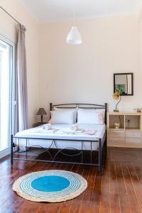 a bedroom with a bed with a blue rug on the floor at Traditional 2-storey Μaisonette with Terrace in Heraklio