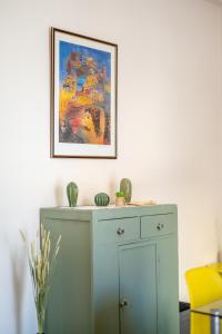 a cabinet in a room with a painting on the wall at Traditional 2-storey Μaisonette with Terrace in Heraklio