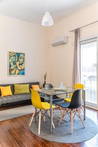 a living room with a glass table and yellow chairs at Traditional 2-storey Μaisonette with Terrace in Heraklio