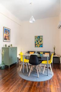 a dining room with a table and yellow chairs at Traditional 2-storey Μaisonette with Terrace in Heraklio