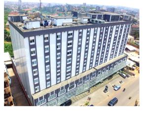 Hotel Franco Yaounde في ياوندي: اطلالة علوية على مبنى ابيض كبير مع شارع