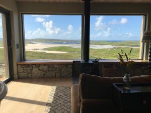 a living room with large windows looking out at the ocean at Uig Sands Rooms in Uig
