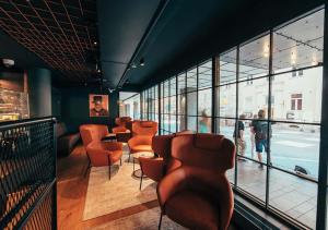 a waiting room with orange chairs and windows at Clarion Hotel Mestari in Helsinki